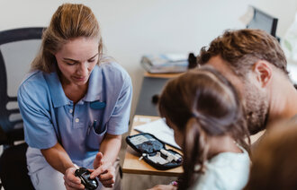 Bildet viser helsepersonell, barn og insulinutstyr