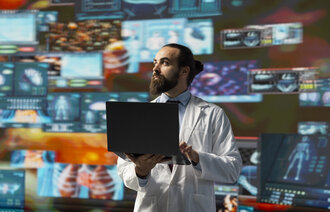 bildet viser sykepleier med pc mot fargerike skjermer