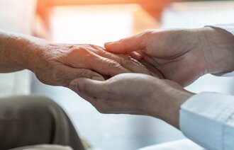 Bilder viser en omsorgsfull hånd som holder en pasients hånd