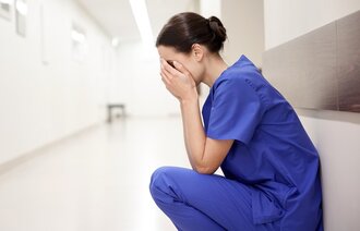 Bildet viser en stresset og sliten sykepleier