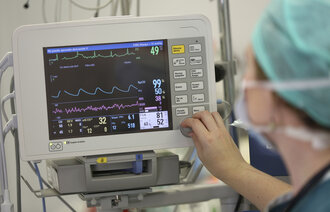 Bilde viser en anestesisykepleier som overvåker en skjerm