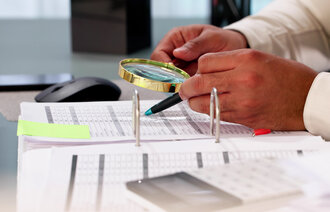 bildet viser en som gransker et papirdokument