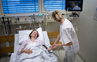 Bilde av sykepleier og pasient på sykehus