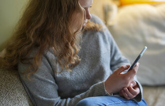 bilde av en jente som leser på mobilen