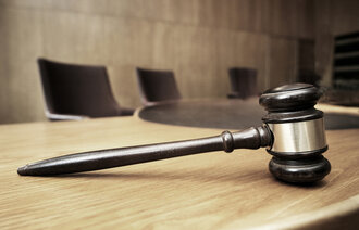 Bildet viser en klubbe på et bord i en rettssal