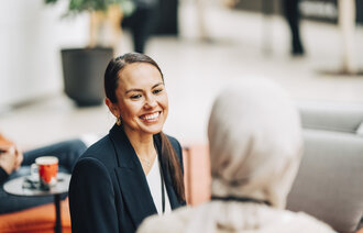 Bildet viser to kvinner som snakker sammen