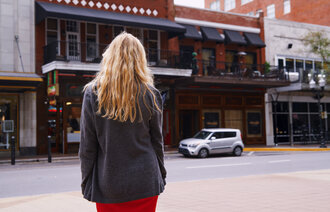 Bildet viser en kvinne som står med ryggen mot kamera.