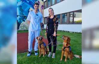 Bildet viser Susanne Rueness Espeseth og barnesykepleier Aleksander Hayes Sundby med terapihundene Aiva og Karma