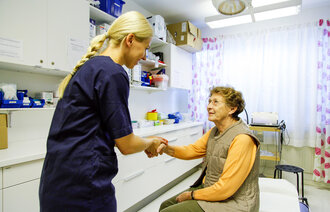 Bildet viser en sykepleier som er med en pasient