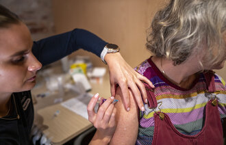 Bildet viser en dame som får vaksine