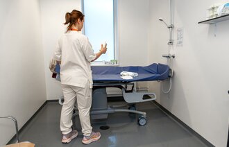 Bildet viser en sykepleier som skal utføre en preoperativ dusj 