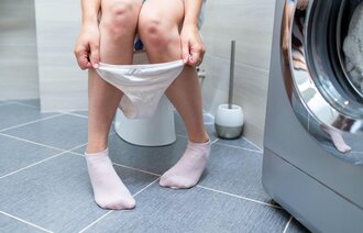 Bildet viser en kvinne som sitter på do.