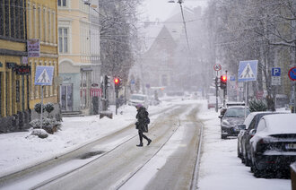Bildet viser en kvinne som går i snøvær.
