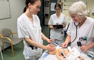 Bildet viser to jordmødre og en barnepleier som trener på nyfødtresuscitering på babydokke