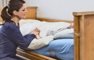 Bildet viser en sykepleier som snakker med en alvorlig syk pasient