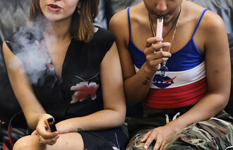 Bildet viser to unge jenter som vaper.