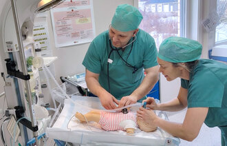 Bildet viser to anestesisykepleiere som simulerer på en babydukke