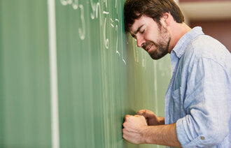 Bildet viser en frustrert mann foran en tavle