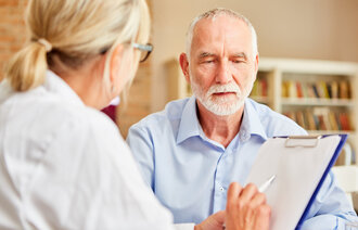 Sykepleier i samtale med pasient.