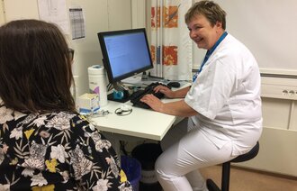 Bildet viser en øyesykepleier som veileder en pasient