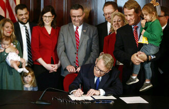 Bildet viser at loven blir undertegnet.