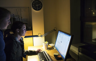 Hjemmesykepleierne Renate Haaland (t.v.) og Annemarthe Aarland er nattevakter. Her sjekker de meldinger på pc.