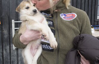 Birgitte koser med en av hvalpene