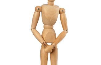 Bildet viser en bevegelig tredukke som står og holder hendene foran skrittet.