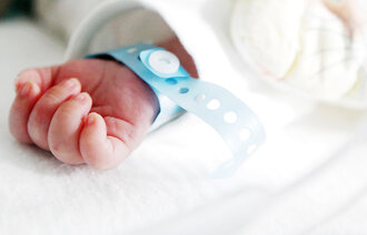 Bildet viser hånden til en nyfødt baby.