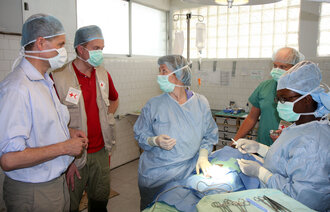 Port-au-Prince, Haiti 20100407. Kirurg Gerd Tranø i aksjon i operasjonssalen på Røde Kors' feltsykehus i Haiti. Utviklingsminister Erik Solheim (tv) og Norges Røde Kors' generalsekretær Børge Brende besøkte sykehuset .