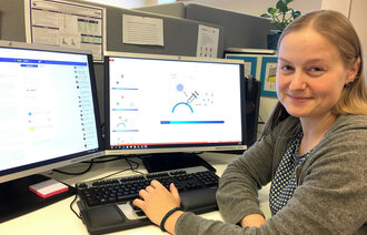 Bildet viser Birgitte Klüwer som sitter foran en datamaskin der skjermbildet viser illustrasjoner på influensavaksine.