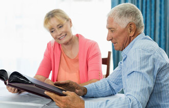 Senior couple looking at photo album in a retirement home