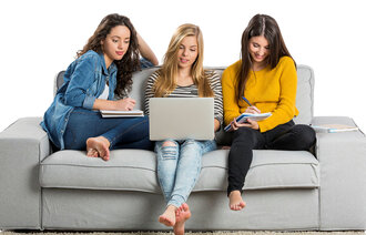 Bildet viser tre unge kvinner som sitter i en sofa med PC og kladdeblokker.