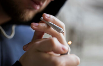 Bildet viser en person som er i ferd med å tenne en joint