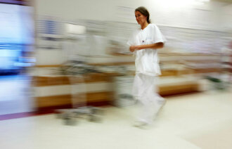 Sykepleier som løper og stresser.