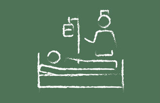 Bildet viser en sykepleier som står ved en pasientseng.