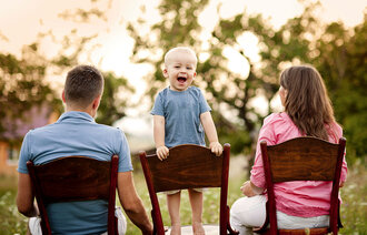 Mor, far og barn på stoler.