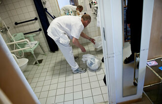 Ufaglært Helge Kristiansen på Vinderen Bo og Servicesenter rydder på badet.