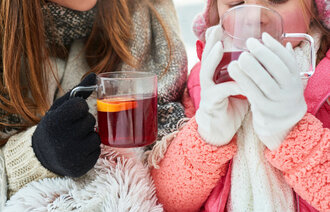 Bildet viser barn som drikker varm drikke ute en vinterdag