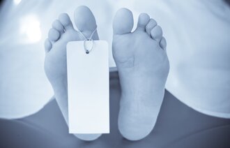 Bilde av føtter på obduksjonstralle med lapp på tåa