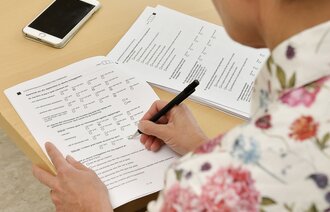 Bildet viser en dame som fyller ut pårørendeskjema