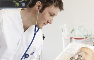 Bildet viser en student som øver på en simuleringsdukke.