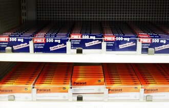 Bildet viser pakninger med smertestillende tabletter, som Paracet og Ibux, i en hylle