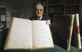 Riksrevisor Lars Breie (1950-1978) med en gammel protokoll. 