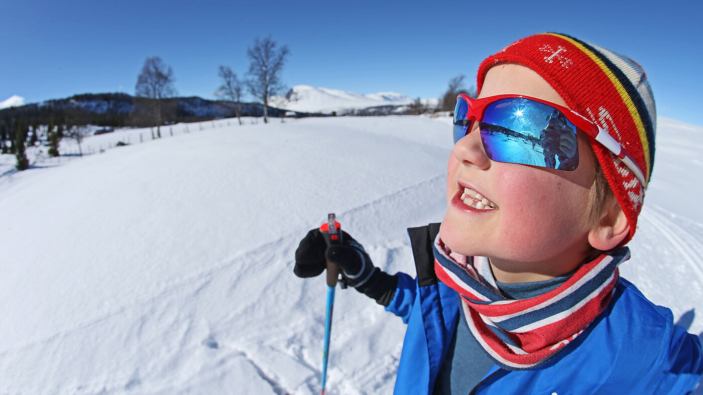 Bilde viser gutt som myser mot sola 