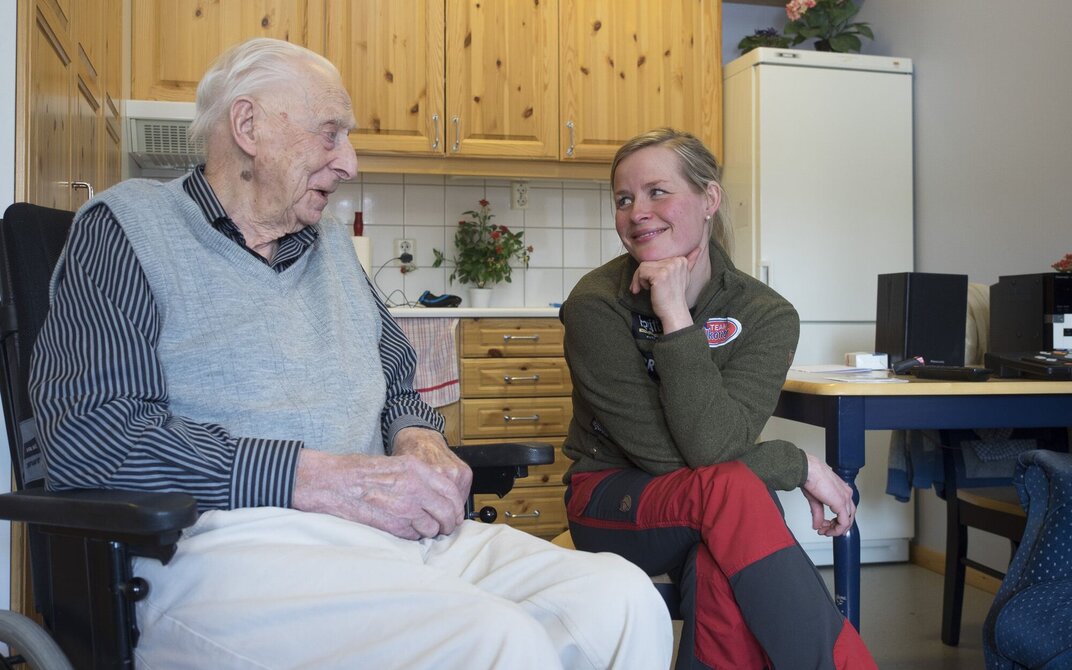Bildet viser Birgitte Næss som er inne hos en beboer og slår av en prat.