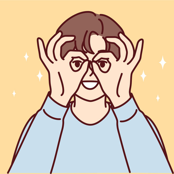 Bildet viser en gutt som lager briller med hendene.