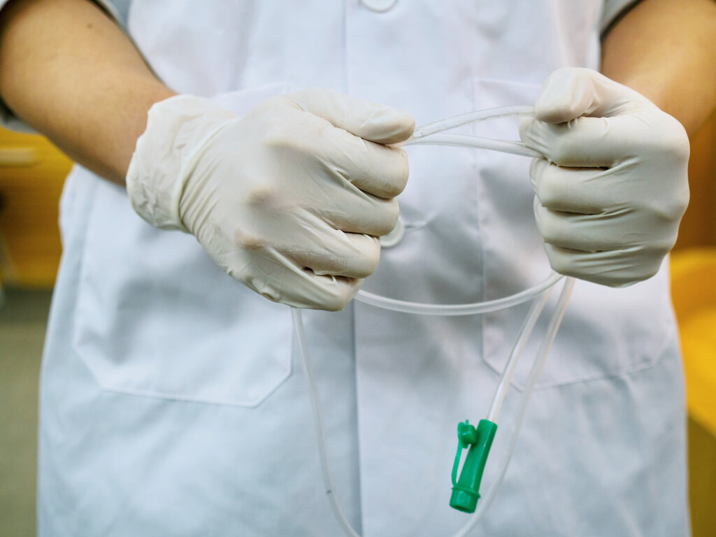 Bildet viser pleier som holder en nasogastrisk sonde