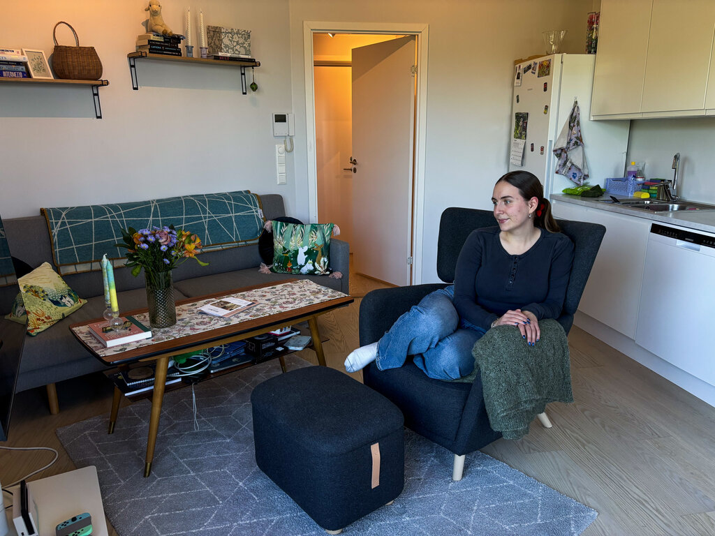 Mille som sitter i en stol i leiligheten