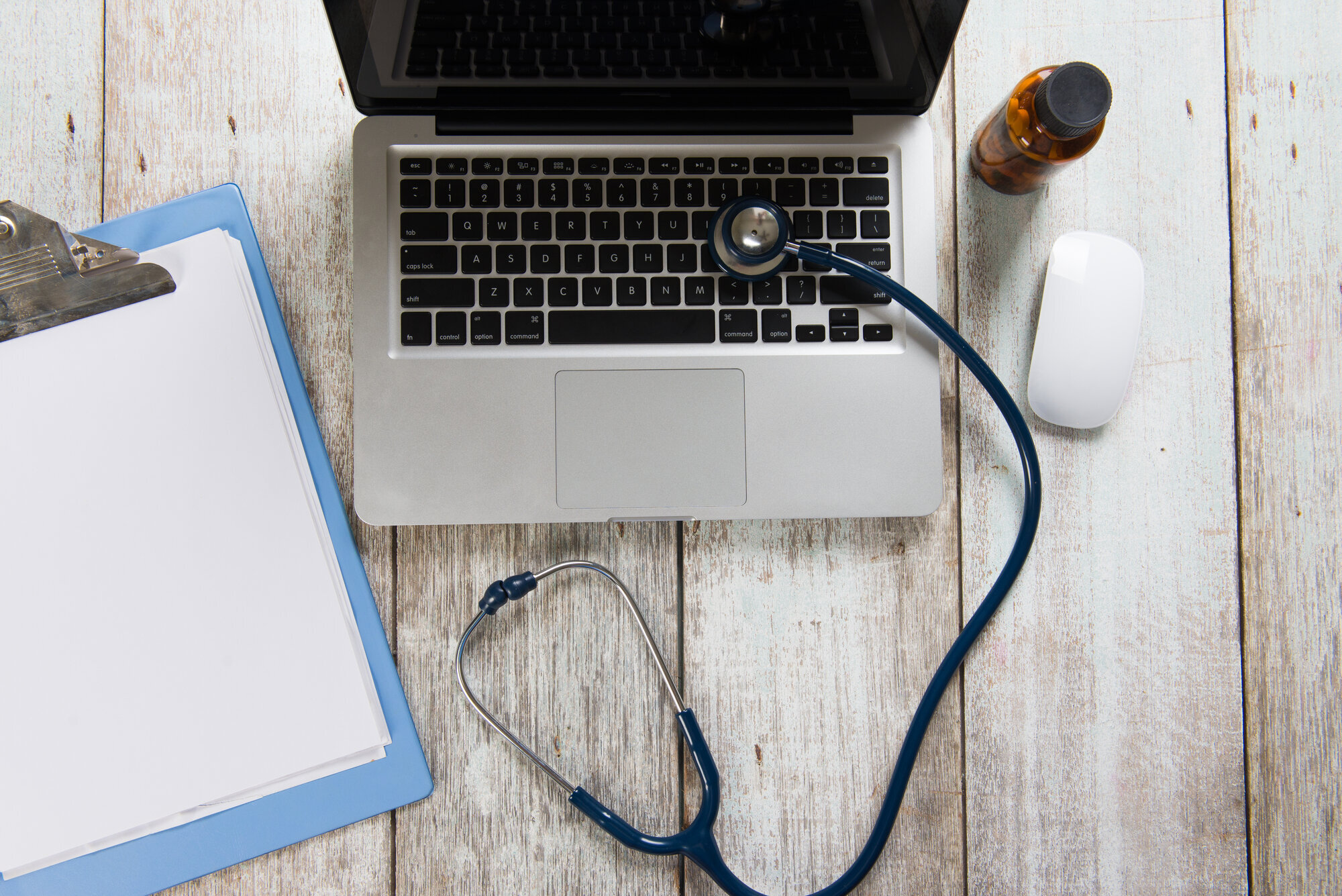 Forskerpult med datamaskin, notatblokk og stetoskop